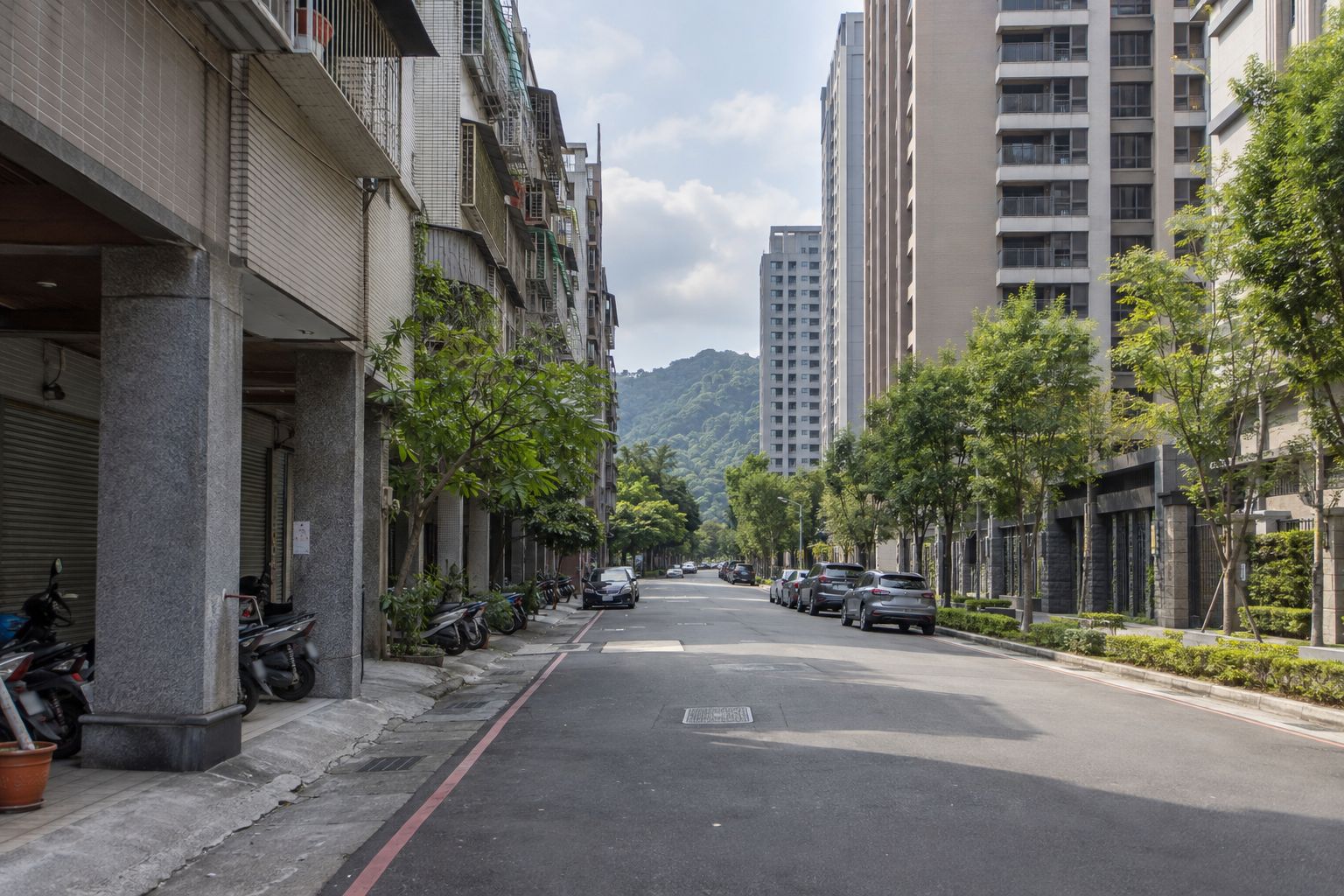 新北住宅街道,一側是騎樓老公寓,一側是新建電梯大樓,路底是山
